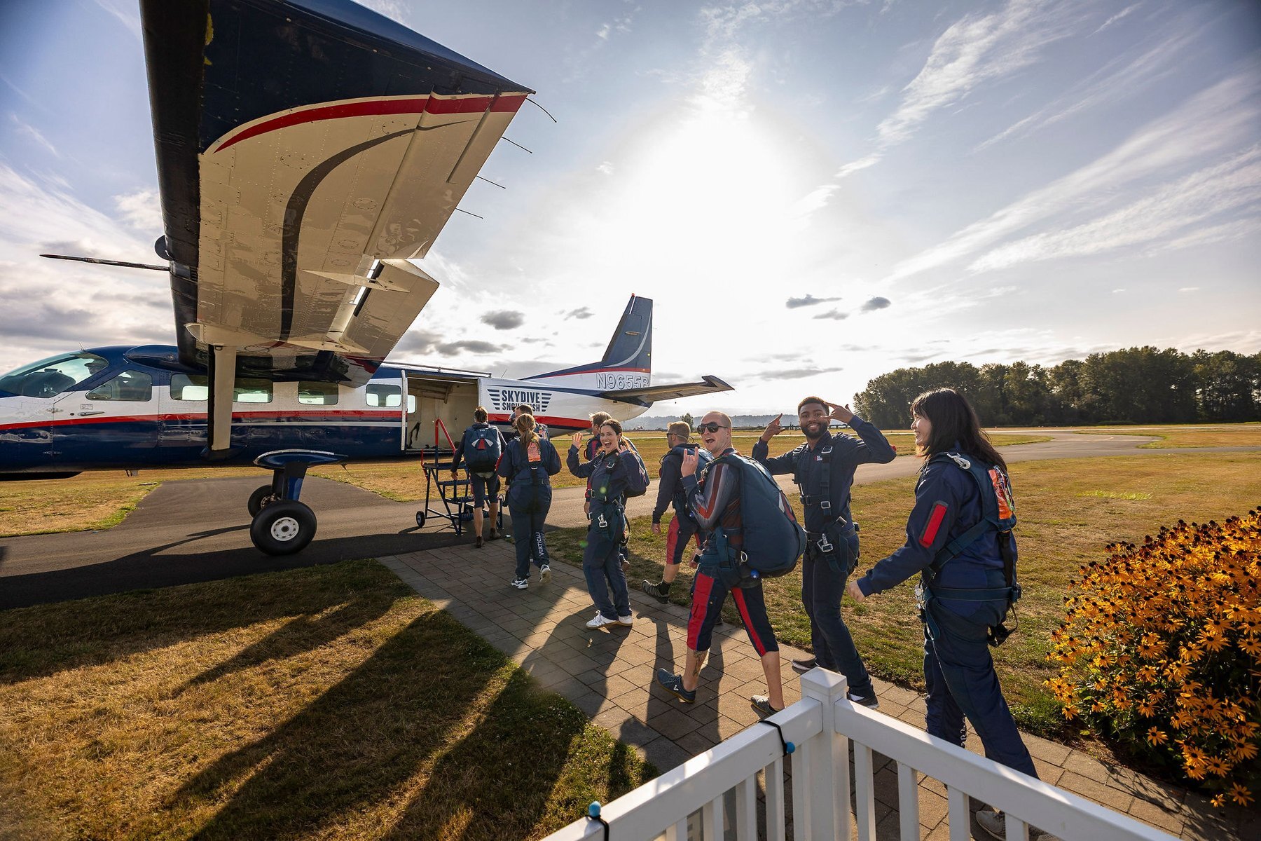 Members in jumpsuits beside the plane before a skydiving experience